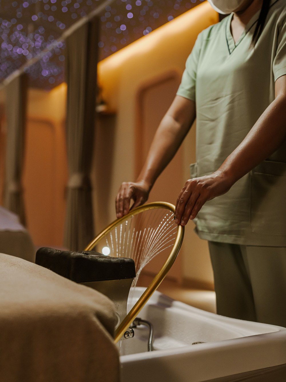 Overhead rain showerhead beside the private spa treatment bed