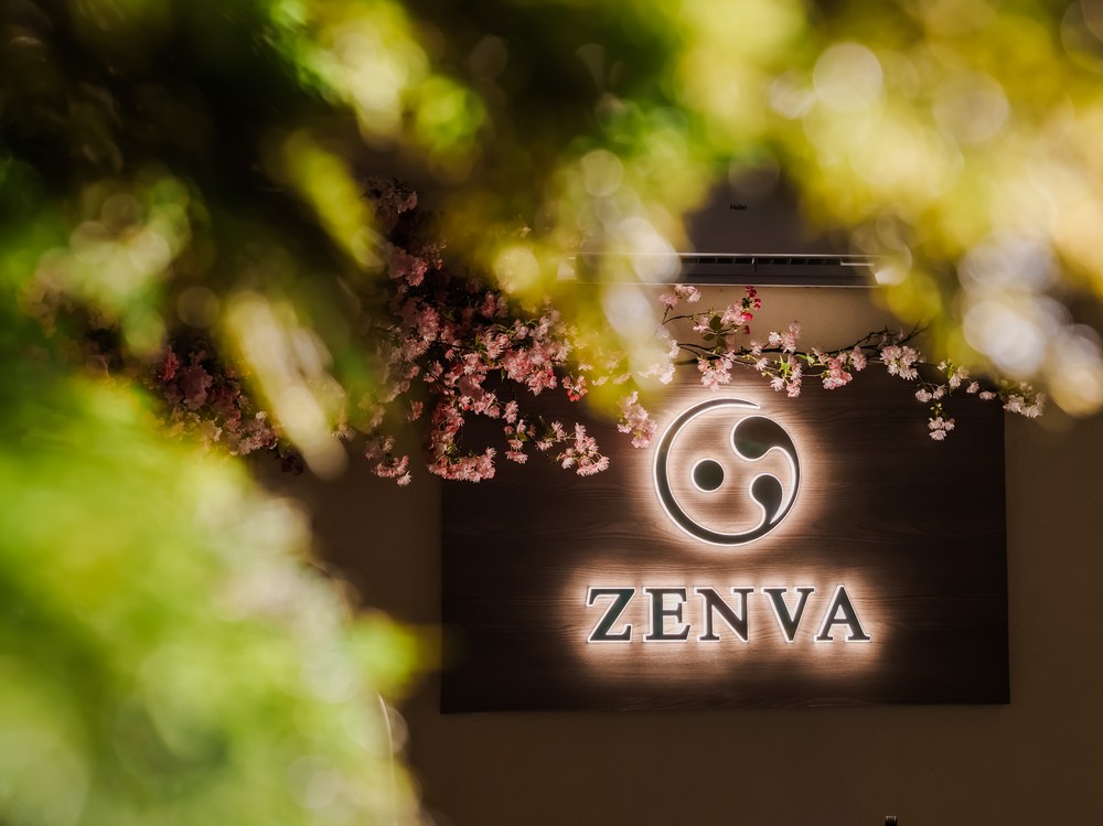 The Zenva sign framed by blossom branches at the entrance