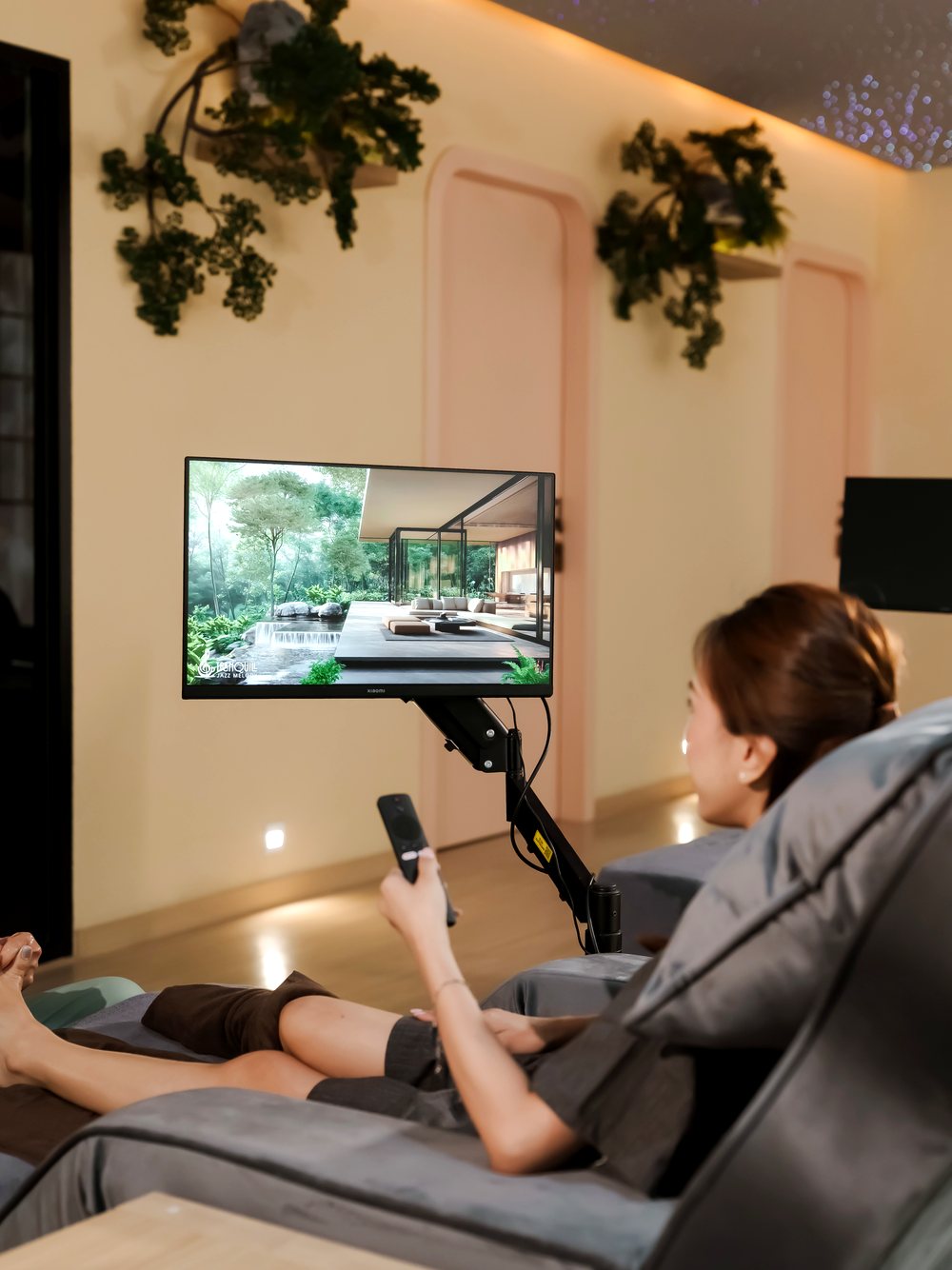 Guest reclining in a premium massage chair, streaming entertainment on the personal screen